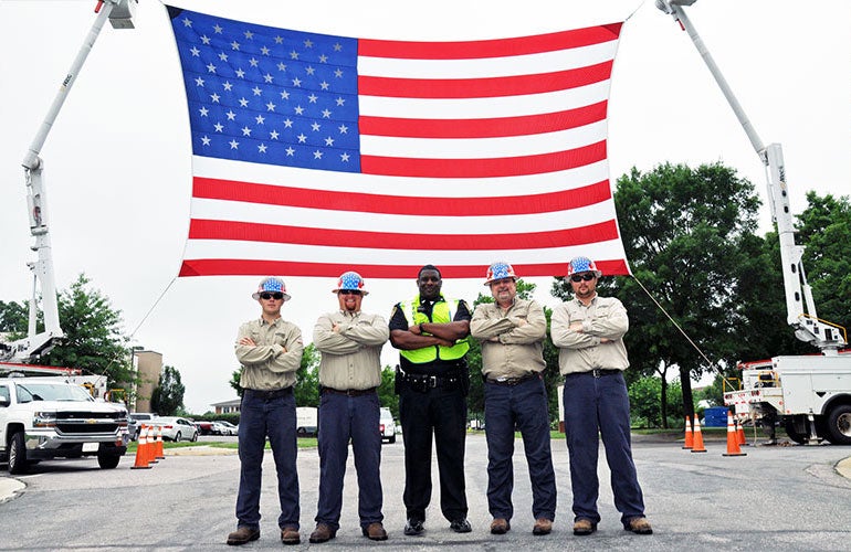 Linemen with Flag and Trucks