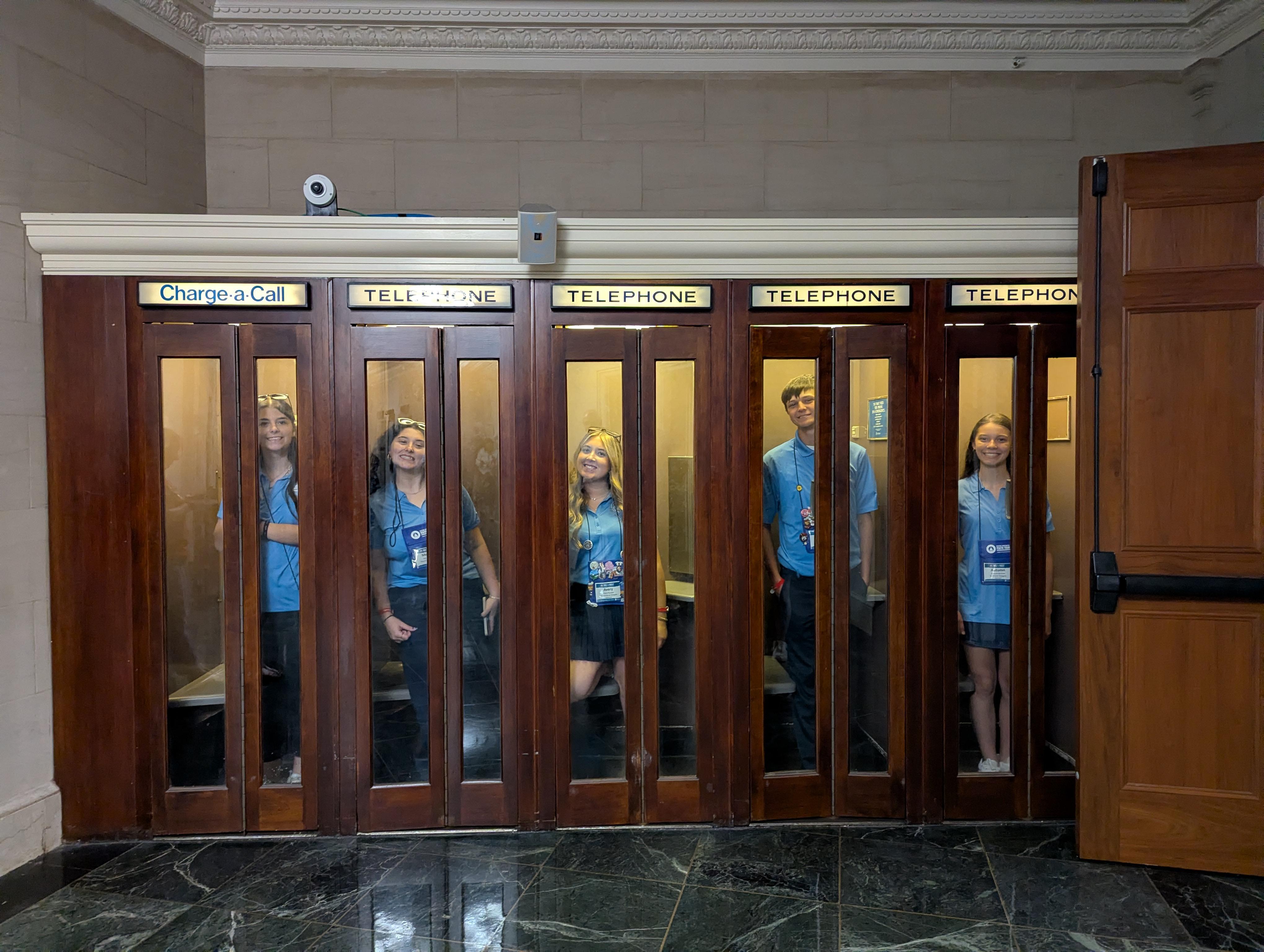 Youth Tour participants stand in phone booths inside of the Capitol